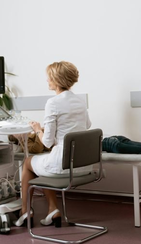 Médica examinando a paciente recostada en la camilla