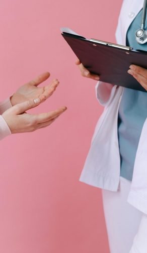 Dos profesionales de salud conversando con una carpeta en mano